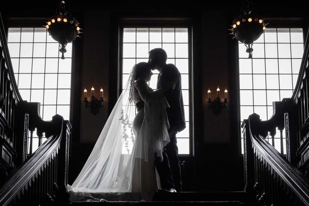 bride and groom sharing an embrace on the staircase at semple mansion