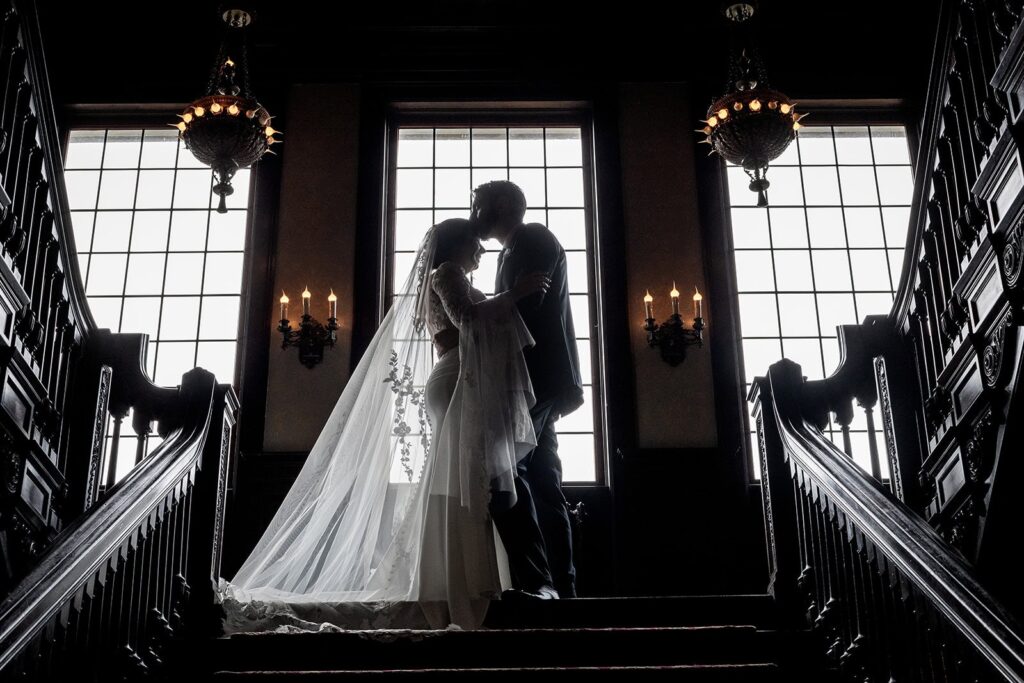 bride and groom epic portrait shot at the top of the stairs at semple mansion