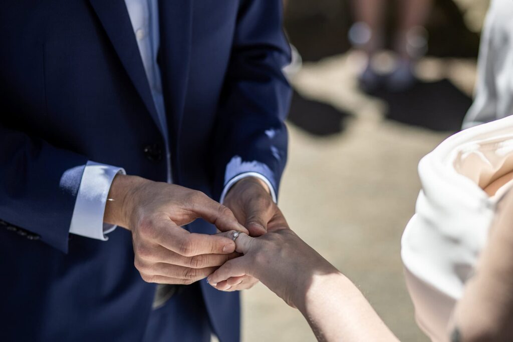bride and groom exchange rings during hoyt arboretum wedding ceremony