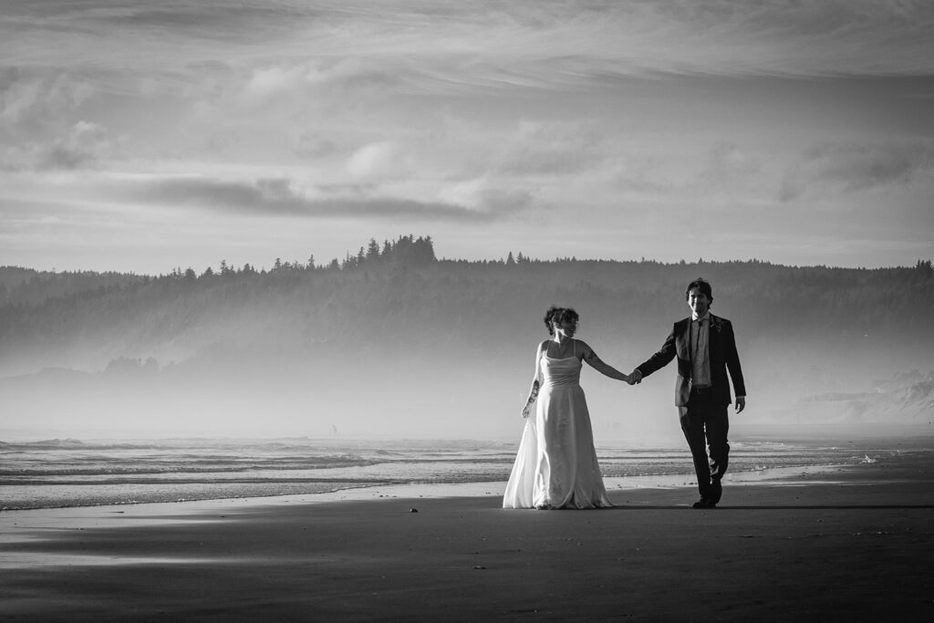 bride and groom walk along cannon beach in oregon