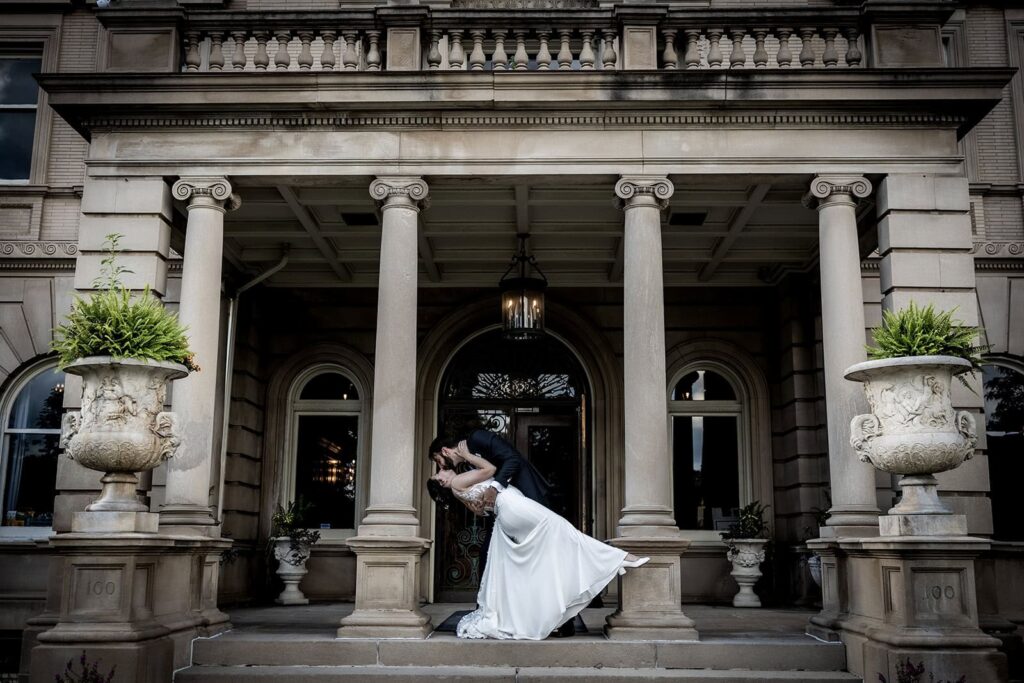 Bride and groom embracing in front of mansion windows at a Semple Mansion Wedding