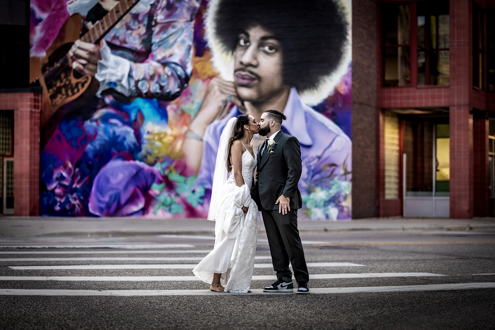 Bride and groom portraits in front of iconic mural wall in downtown mpls
