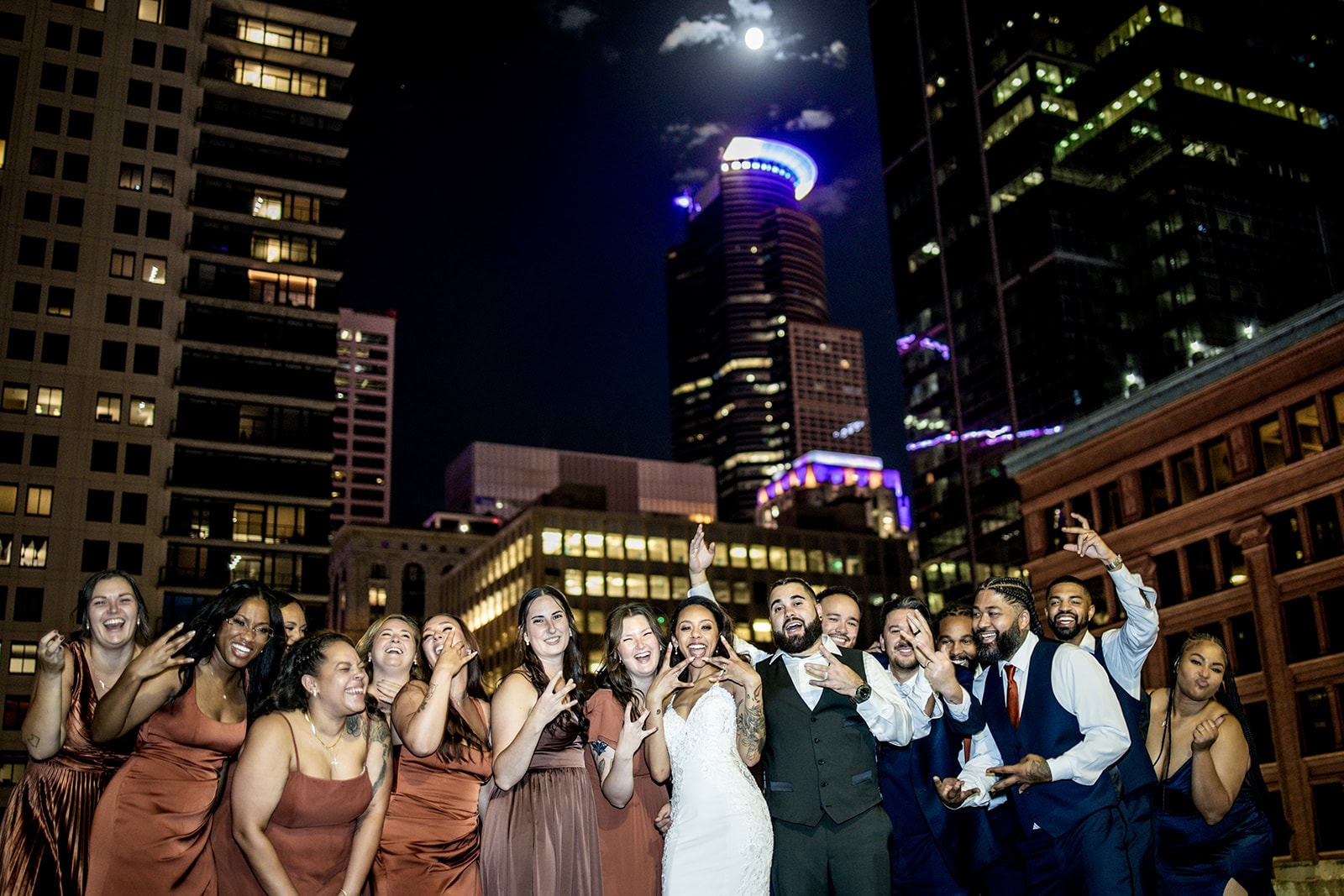 Wedding party rooftop portrait overlooking downtown Minneapolis at night.