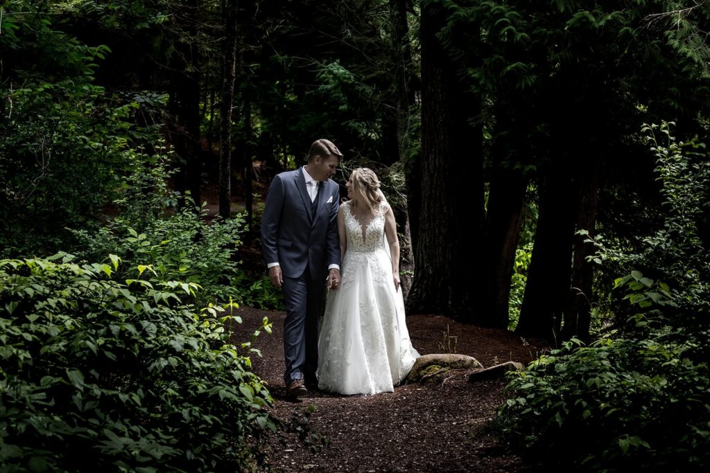 bride and groom during minnesota small wedding walking through forest