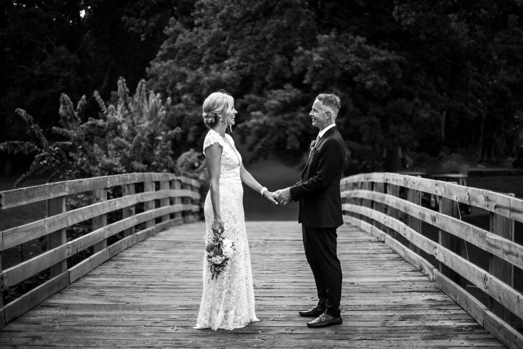 black and white image of groom holding one of the bride's hands during minnesota elopement
