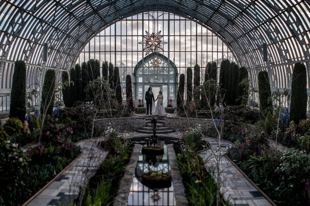 Couple posing inside conservatory wedding venue in St Paul