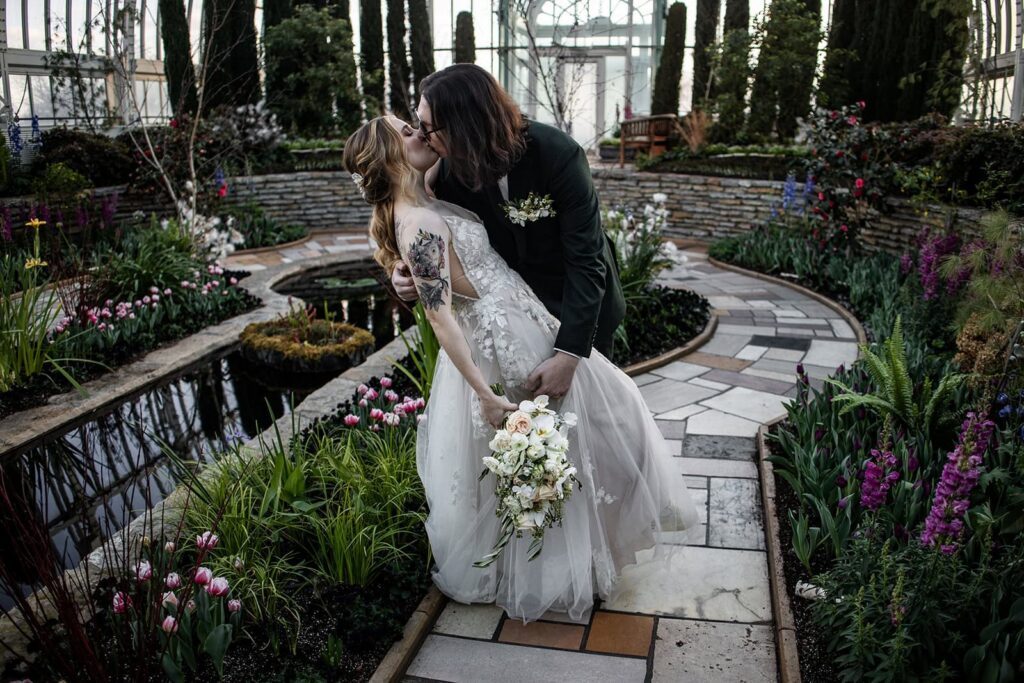 Groom dipping bride after their Como Zoo Conservatory wedding ceremony in St. Paul