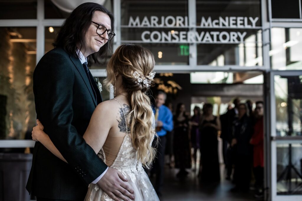 Couple swaying together during their first dance with soft lighting at Como Park
