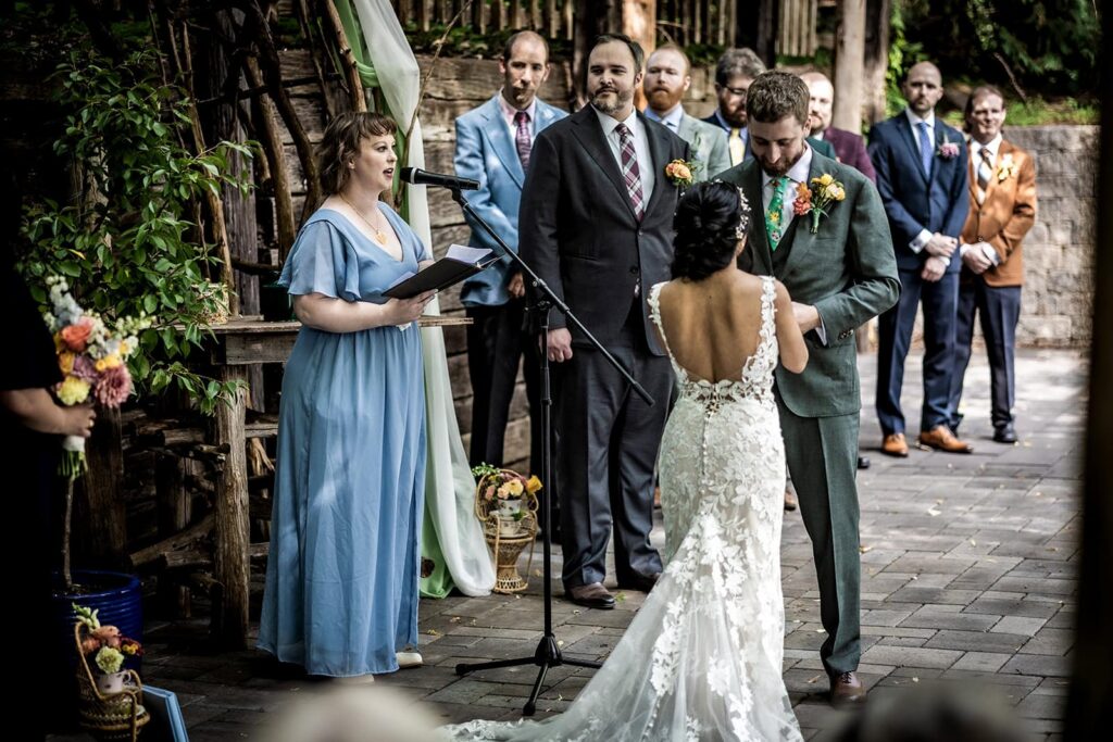 Wedding ceremony in early August surrounded by greenery at minnesota venue