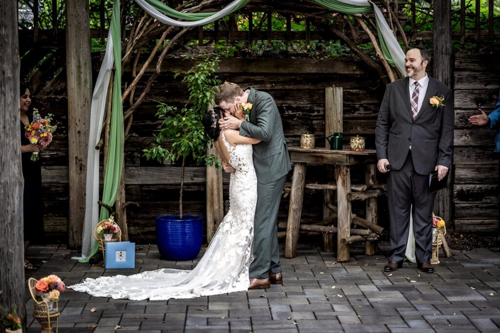 Bride and groom sharing their first kiss at a Minnesota summer wedding