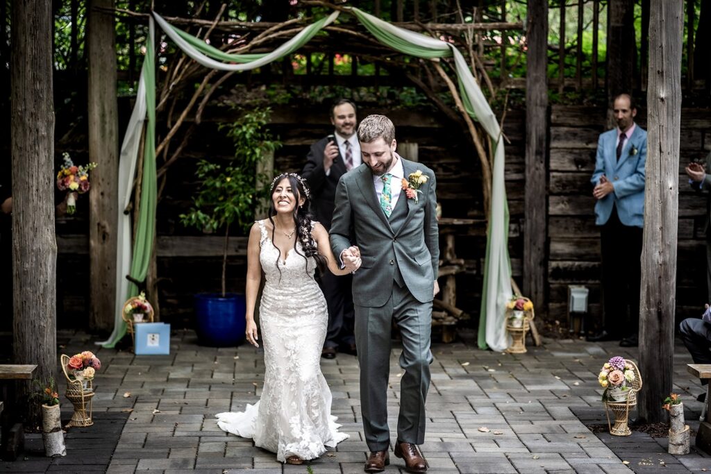 newly married couple walking down the aisle during their gardens of castle rock wedding day