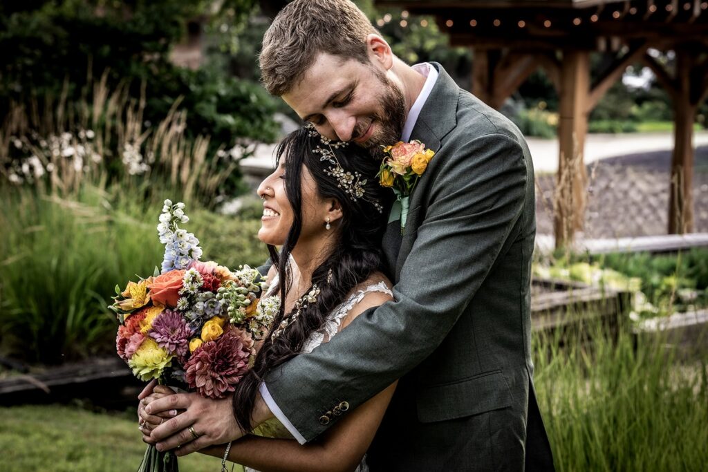 Bride and groom laughing together during summer wedding portraits in Minnesota