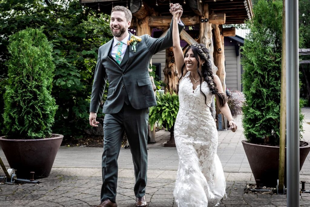 happy couple makes a grand entrance into their gardens of castle rock wedding reception