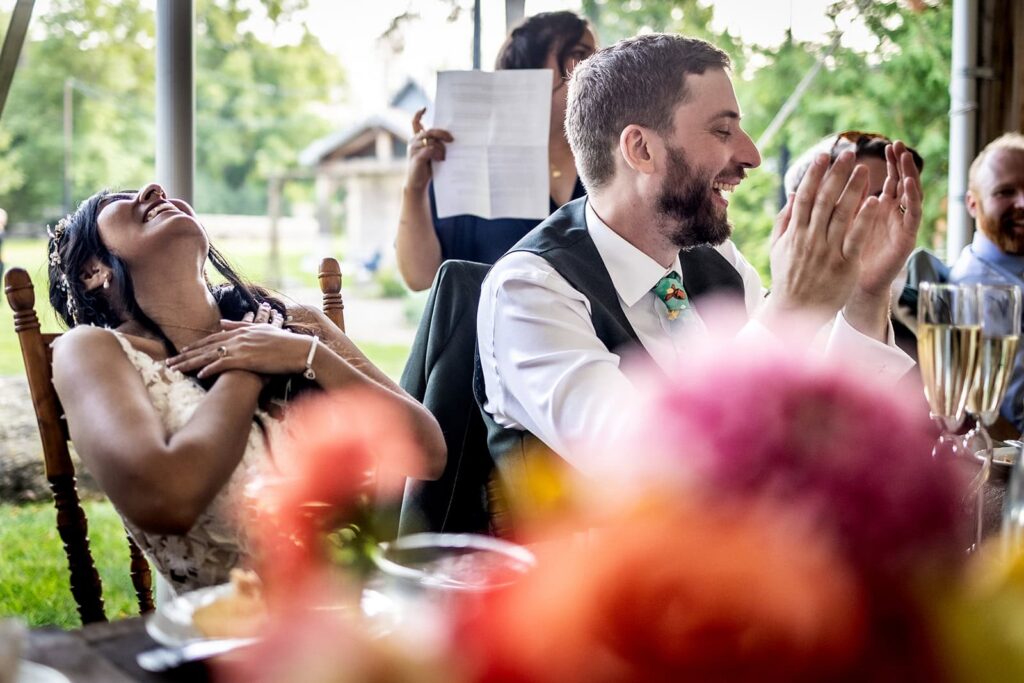 bride and groom laughing hysterically during wedding speeches at minnesota wedding venue
